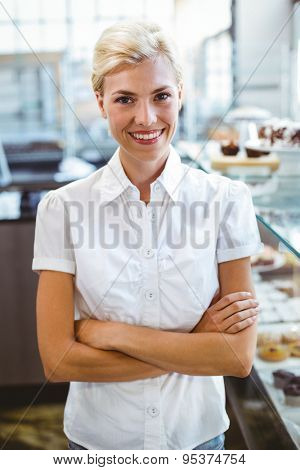Selfassured female cook smiling in front of her bakery