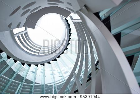 modern glass spiral staircase with metallic hand-rails.