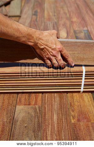 Ipe decking installation with carpenter hands holding tropical wood slats