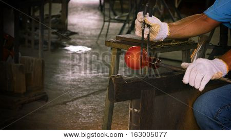 Unidentified Man forming a hot glass at Ryukyu Glass Village Okinawa Japan.