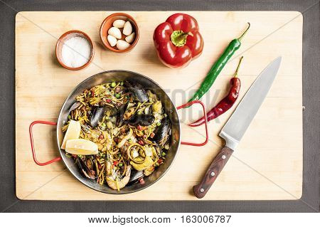 Italian pasta fideua with seafood, oysters, black pasta