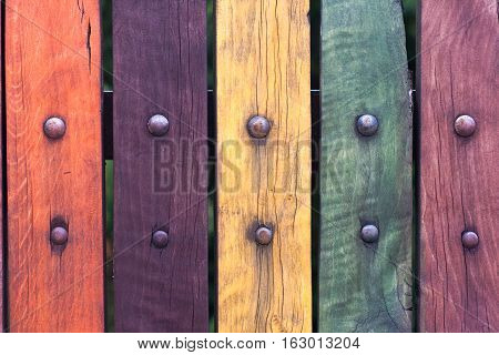 Colorful fence with nails close up. Red, purple, yellow, green. Old.