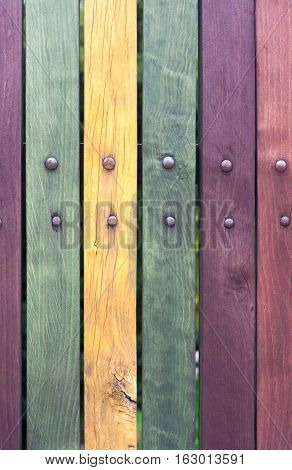 Colorful fence with nails close up. Red, purple, yellow, green. Old.