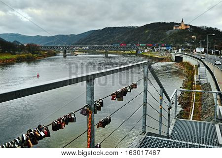 Usti nad Labem Ustecky kraj Czech republic - November 20 2016: afternoon view from iron bridge with locks to river Elbe railway bridge with freight train and castle Vetruse on background