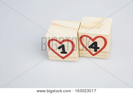 Wooden cubes with handwritten 14th and red hearts. Empty space.