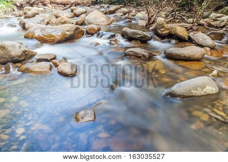 Smooth flowing water through the natural rock creek.
