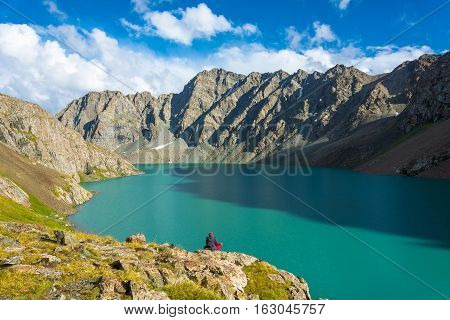 The Woman Meditates On The Shore Of A Mountain Lake Ala-kul, Kyrgyzstan.