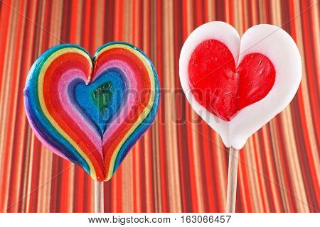 Valentine's Day heart shaped lollipops on a colored background