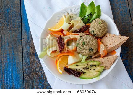 Zucchini pasta with tofu lentil balls avocado carrots. Vegan healthy lunch or dinner. Love for a healthy raw food