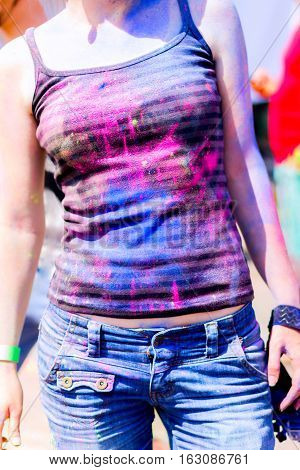 Conceptual shooting of girl's body parts stained with colorful powder during Holifest