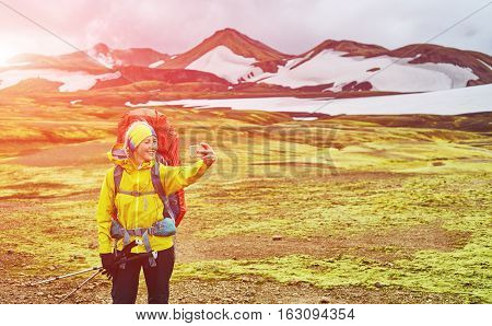 woman hiker photographer taking selfie on the rhyolite mountains background in Iceland