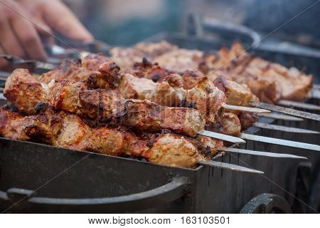 Marinated in spices cut into pieces and put on a skewer pork roasted on coals. Preparation of meat products on the grill and barbecue.