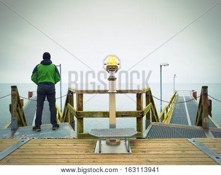 Man On Long Touristic Mole, Autumn Cold Morning. Tourist At Handrail.