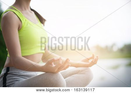 close up of woman perform meditating yoga on the nature background in the morning