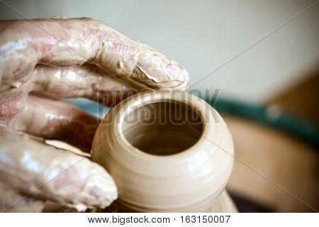 Girl sculpts in clay pot closeup. Modeling clay close-up. Caucasian man making vessel daytime of white clay in fast moving circle. Art creativity. Ukraine cultural traditions. Hobbies