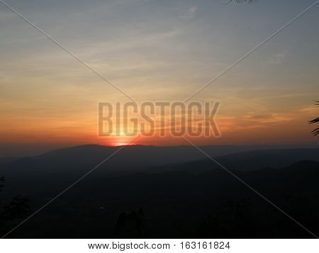 Orange and blue sunset afterglow over the silhouette of mountain range, Thailand
