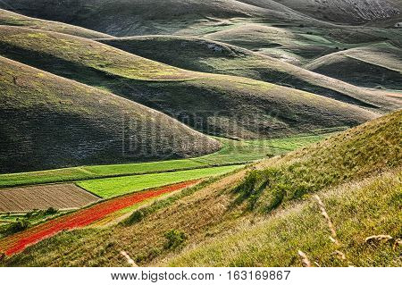 The sun when it rises behind Mount Vettore creates a light-shadow effect in the hills below