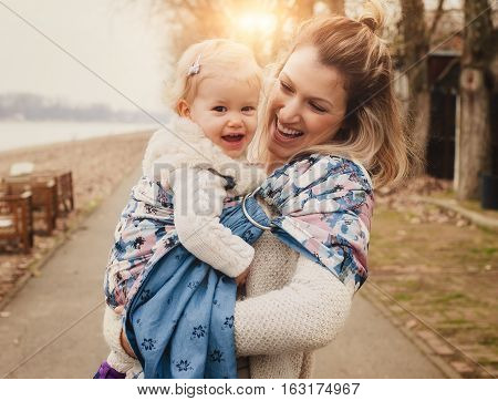 Young Mother Having Her Little Daughter In Baby Carrier Scarf