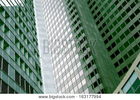 Modern tall buildings with green tone. Offices.