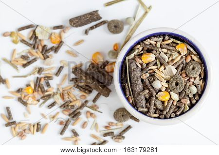 dry food for rodents in bowl on white background top view.
