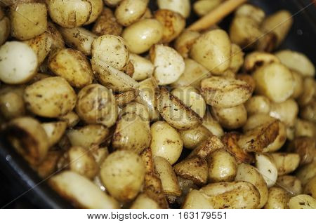 Roasting young potato with Provence herbs in a frying pan