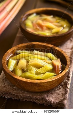 Fresh homemade rhubarb compote in wooden bowls photographed with natural light (Selective Focus Focus in the middle of the first compote)