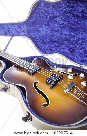 A vintage semi-acoustic archtop bass guitar with sunburst finish in original tweed case.