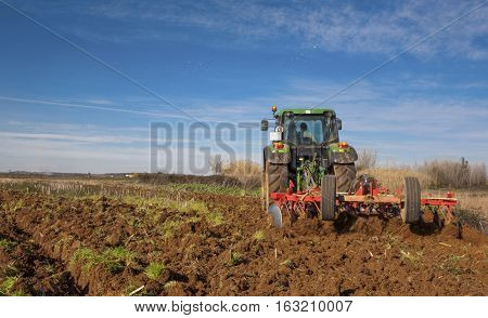 Farm tractor preparing the soil and ranking the field before planting Montijo Badajoz Extremadura Spain