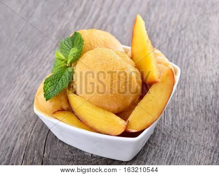 Peach sorbet in bowl on wooden background