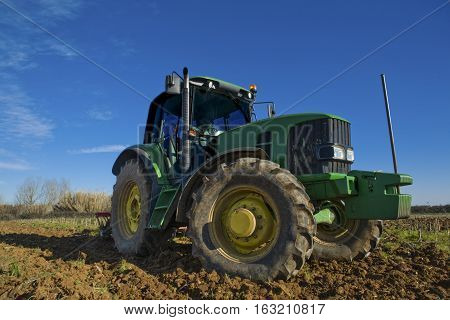 Farm tractor preparing the soil and ranking the field before planting Montijo Badajoz Extremadura Spain