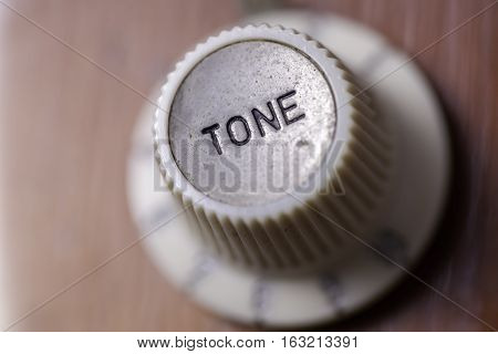Vintage tone. Focus on a retro tone dial from a vintage guitar.