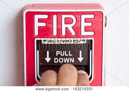 Hand pull down fire alarm switch on factory wall