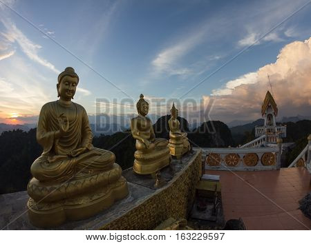 Statues of Buddha at Tiger Temple on the top of karst mount at sunset Krabi Province Thailand