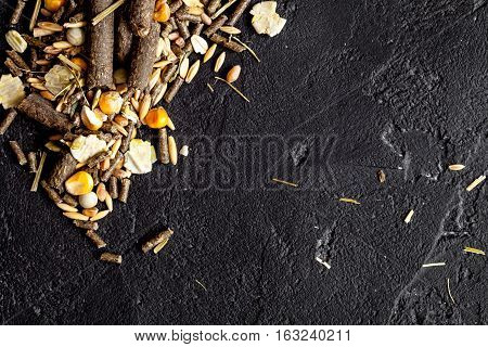 dry food for rodents on dark background top view.