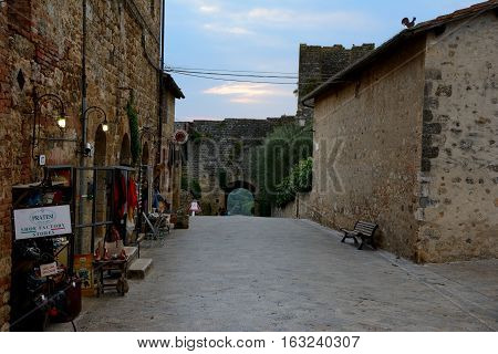 Monteriggioni Italy - September 7 2016: Buildings and narrow street in Monteriggioni city in Tuscany Italy. Unidentified people visible.