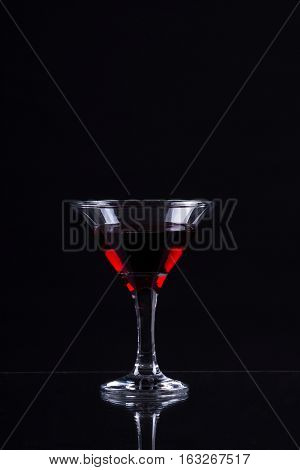 Red Wine In A Glass Of Martini On A Black Background