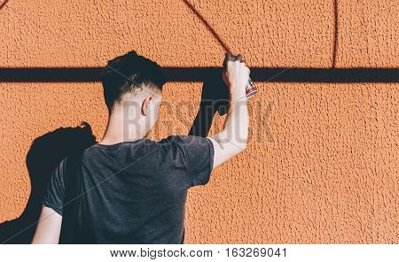 Man writing graffiti on the urban walls