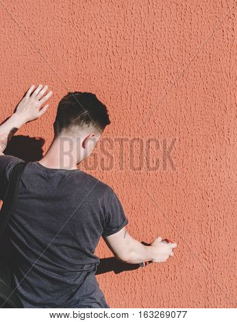 Man writing graffiti on the urban walls