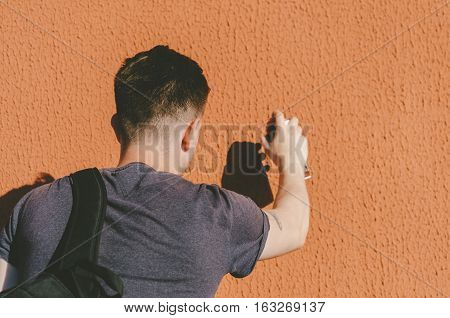 Man writing graffiti on the urban walls