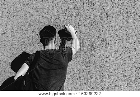 Man writing graffiti on the urban walls