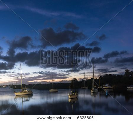 Boats sitting in the lake at sunset in Yamba, Australia