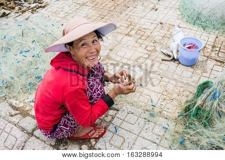 Nha Trang VIETNAM - December 282016 : Vietnamese woman fisherman unravels fishing net