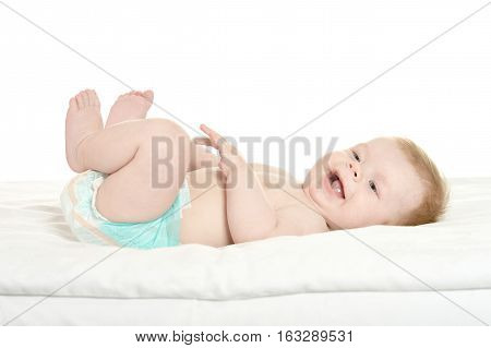 dorable baby boy in pampers on blanket on a white background