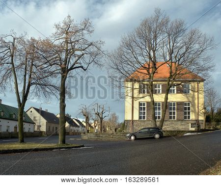 Tisa Ustecky kraj Czech republic - december 10 2016: village common with elementary school building and a parked car during the winter tourist season without snow