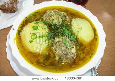 Soup with meat in white round dish