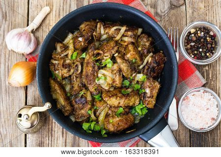Fried beef liver with onions, curry and spices. Studio photo