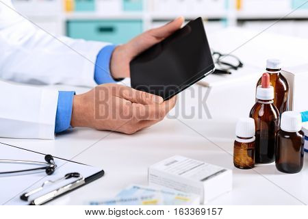Doctor's Hands Working On A Digital Tablet At His Office