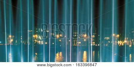 AMSTERDAM, NORTH HOLLAND/THE NETHERLANDS - DECEMBER 3, 2016: View of  Prins Hendrikkade through the illuminated fountain during the Light Festival