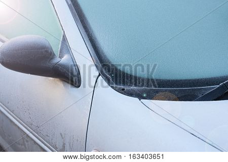 Frozen windshield wiper on car. Frozen windshield. Frozen grey car. car windshield in winter. Frozen front window of a car. Frozen car windshield in winter. Front Glass