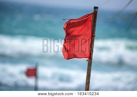Red warning flag on beach showing that swimming is dangerous or prohibited
